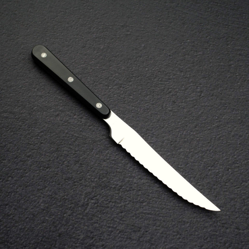 Aogami #2 鋼硬度約 61–63 HRC，添加鎢與鉻以提升韌性與刃口保持性，同時維持良好研磨性。由於此刀採用反應性軟鐵夾層而非不鏽鋼，使用後需立即擦乾並薄塗食用油，以防生鏽。八角 Black Chacate 握柄提供耐用木質握感，質地細膩、色澤深棕。這種三枚夾芯結構搭配「工作馬」研磨，非常適合習慣保養高碳鋼刀具的使用者。