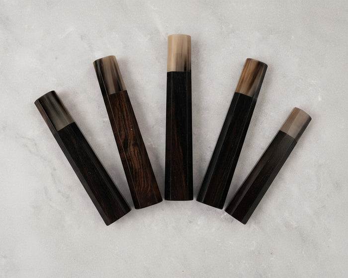 Set of six wooden objects with black and brown finishes on a gray surface