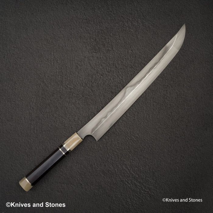 Left: Nigara Blue 2 honyaki, with the wavy hamon running along the middle of the blade. Right: Sukenari SG2, sold as Honyaki: one even finish, and the straight line is the bevel (shinogi), not a hamon.